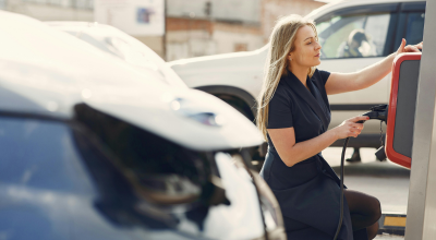 chica cargando coche eléctrico