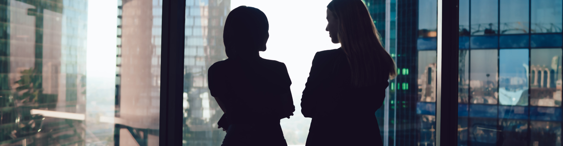 Dos mujeres mirando por la ventana de su oficina