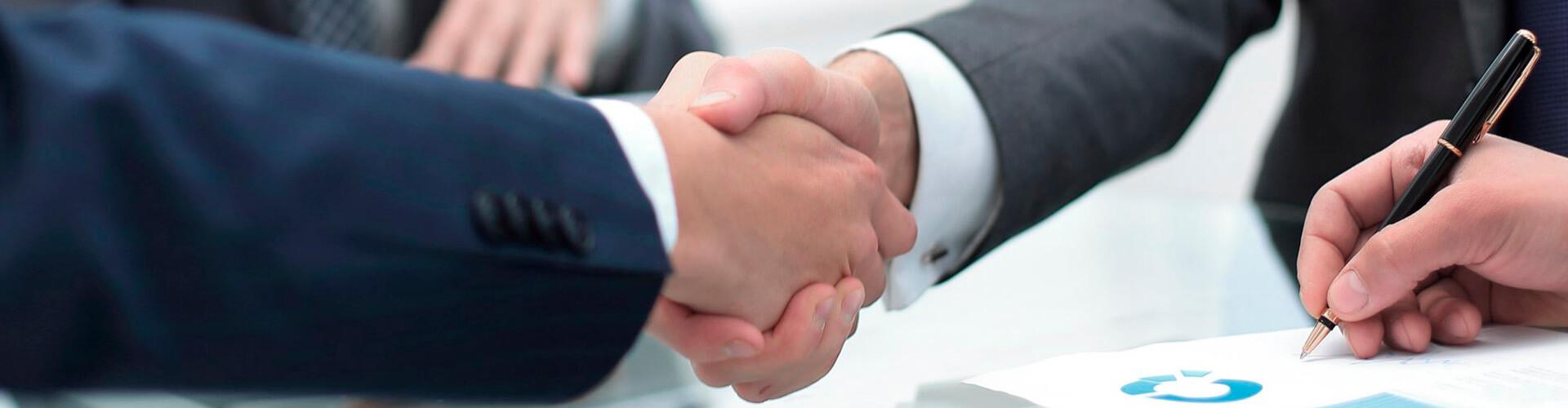 Préstamo Empresas - Dos hombre se dan la mano en una reunión en la oficina