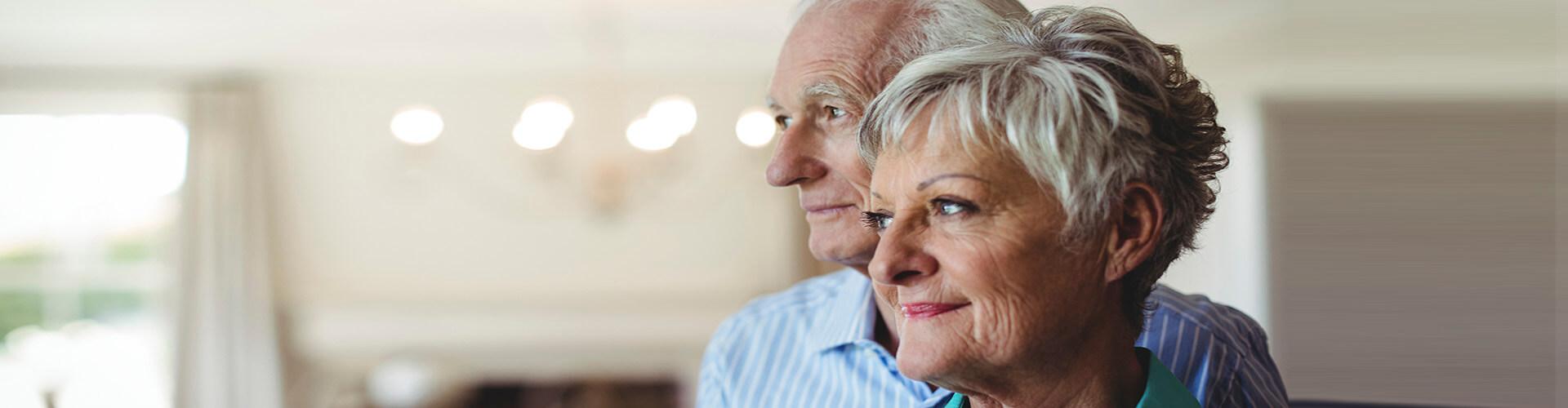 Seguros de Rentas - Pareja senior sonriendo en el salon de su casa