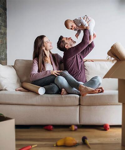 Ventajas para particulares - Pareja con hijo felices haciendo la mudanza de su nueva casa 